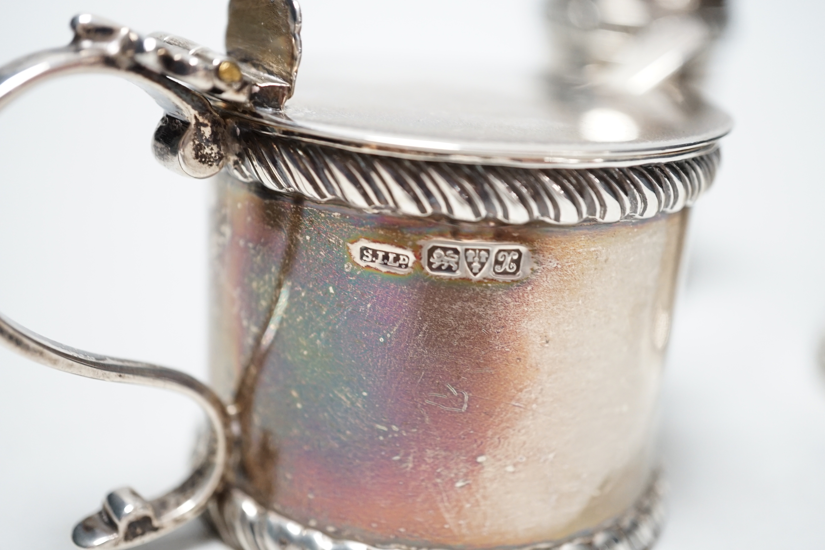 A George V three piece silver condiment set, Stokes & Ireland, Chester, 1923 and two associated spoons.